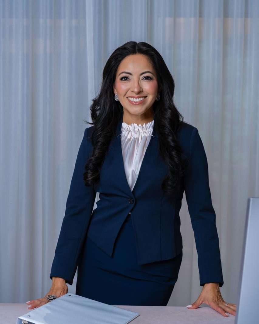 Woman in a navy suit and white blouse beside a desk with documents, Toronto corporate headshot